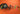 Assorted gourmet chocolates, truffles, chocolate bars, and a jar of chocolate spread are arranged on an orange surface, with some chocolates in colorful wrappers and an open blue box displaying neatly arranged chocolates. - AI generated text