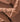 Close-up of broken pieces of chocolate, showing rough and smooth textures with jagged edges and powdered chocolate dust scattered across the surfaces. - AI generated text