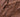 Close-up of a textured chocolate surface with visible pieces of nuts or crisped rice embedded throughout, featuring glossy and jagged ridges. - AI generated text