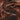 Smooth, swirled chocolate ice cream or mousse topped with small, crunchy chocolate or cocoa nib bits, creating a rich and textured surface. - AI generated text