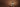 A stack of ladyfinger cookies topped with whipped cream, chocolate sauce splashing around, and a Ferrero Rocher chocolate on top, set against a plain brown background. - AI generated text