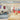 A brightly lit Venchi chocolate shop with a modern interior, featuring a counter with treats and a display of chocolates. Shelves and a table with products are visible, along with decorative wallpaper and the Venchi logo above. - AI generated text