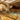 Elegant gelato shop interior with ornate ceilings, gold accents, and display cases filled with colorful gelato flavors. Decorative mirrors and shelves line the walls; velvet ropes guide customers in front of the counter. - AI generated text