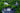 A refined gathering set amidst nature’s embrace, evoking Italian tradition—notes of "Piedmont Hazelnut" and "Sicilian Blood Orange". Aerial view of an outdoor theater and large audience, surrounded by trees and a pond, near a historic stone castle. - AI generated text