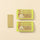 A Pistachio Chocobiscuit Snack Bar from a set of six rests beside eight wrapped Chocoviar bars on an elegant beige background. - AI generated text